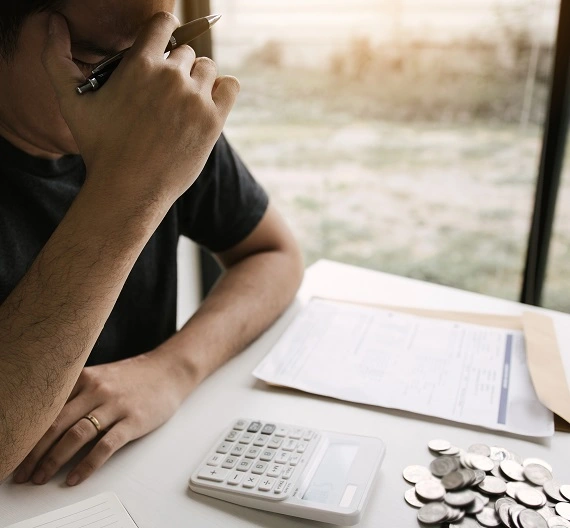 um homem fazendo contas e anotações do seu controle financeiro