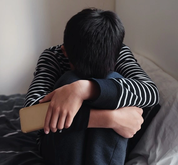criança chateada por sofrer cyberbullying