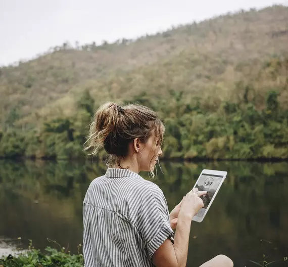 mulher mexendo em tablet representando a internet das coisas (IoT)