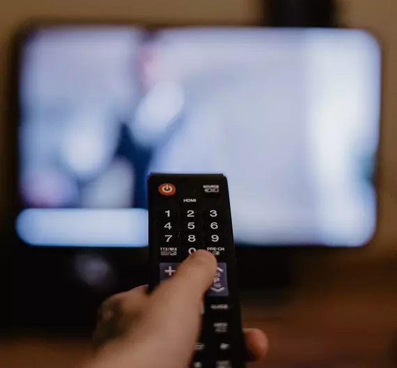 homem com controle remoto na mão dando play em séries longas