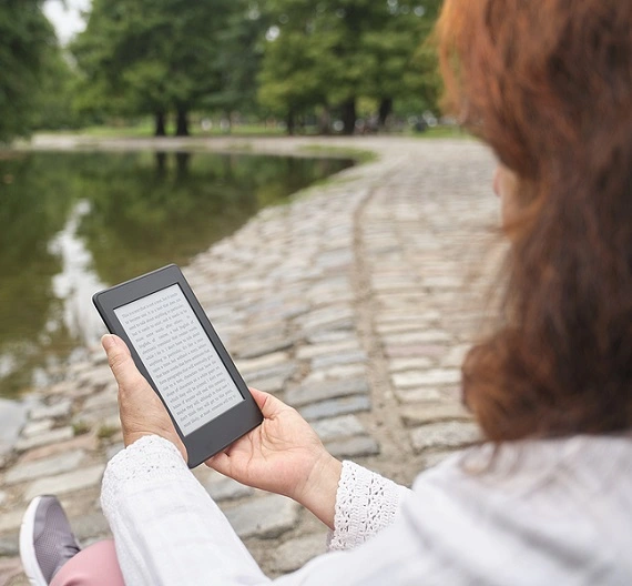 mulher lendo por meio de aplicativos de leitura gratuitos